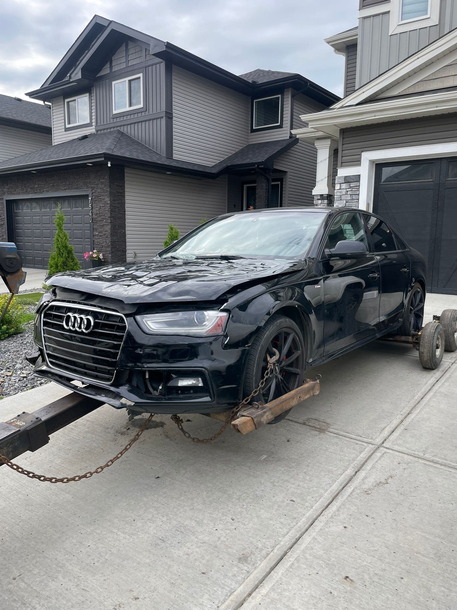 Damaged black Audi prepared for cash-for-cars pickup by an Edmonton auto wrecker