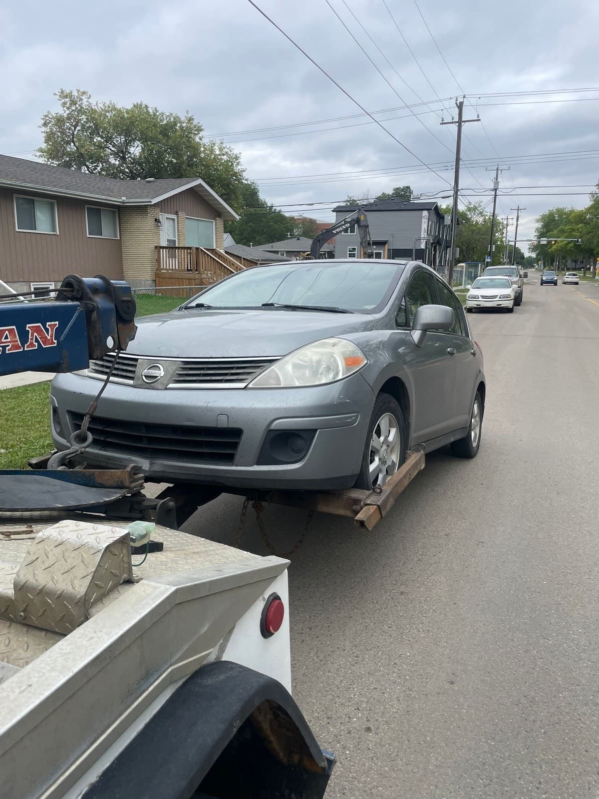 Nissan Versa secured to a wheel-lift tow truck for cash for scrap cars service in Edmonton