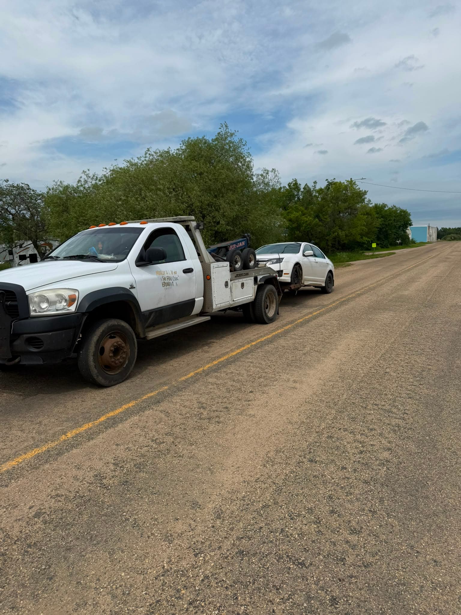 White 2011 Ford Fusion loaded behind a tow truck near Lamont Alberta